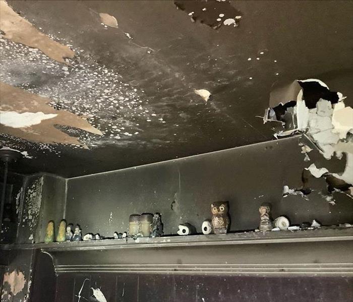 Fire damage to ceiling, wall, and contents.